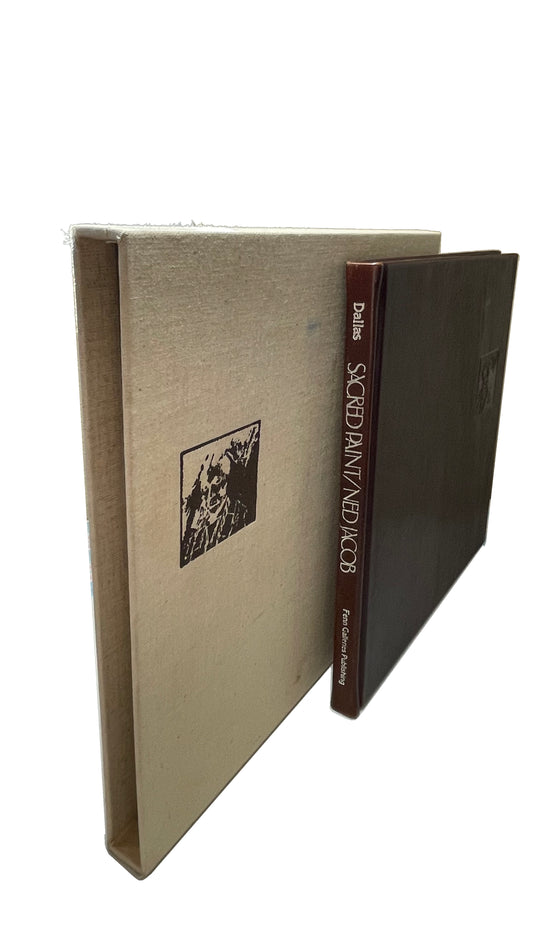 Ned Jacob's Sacred Paint, with brown spine and dark cover beside its pale cloth slipcase, retaining the cloth texture, wear and frayed fibers.