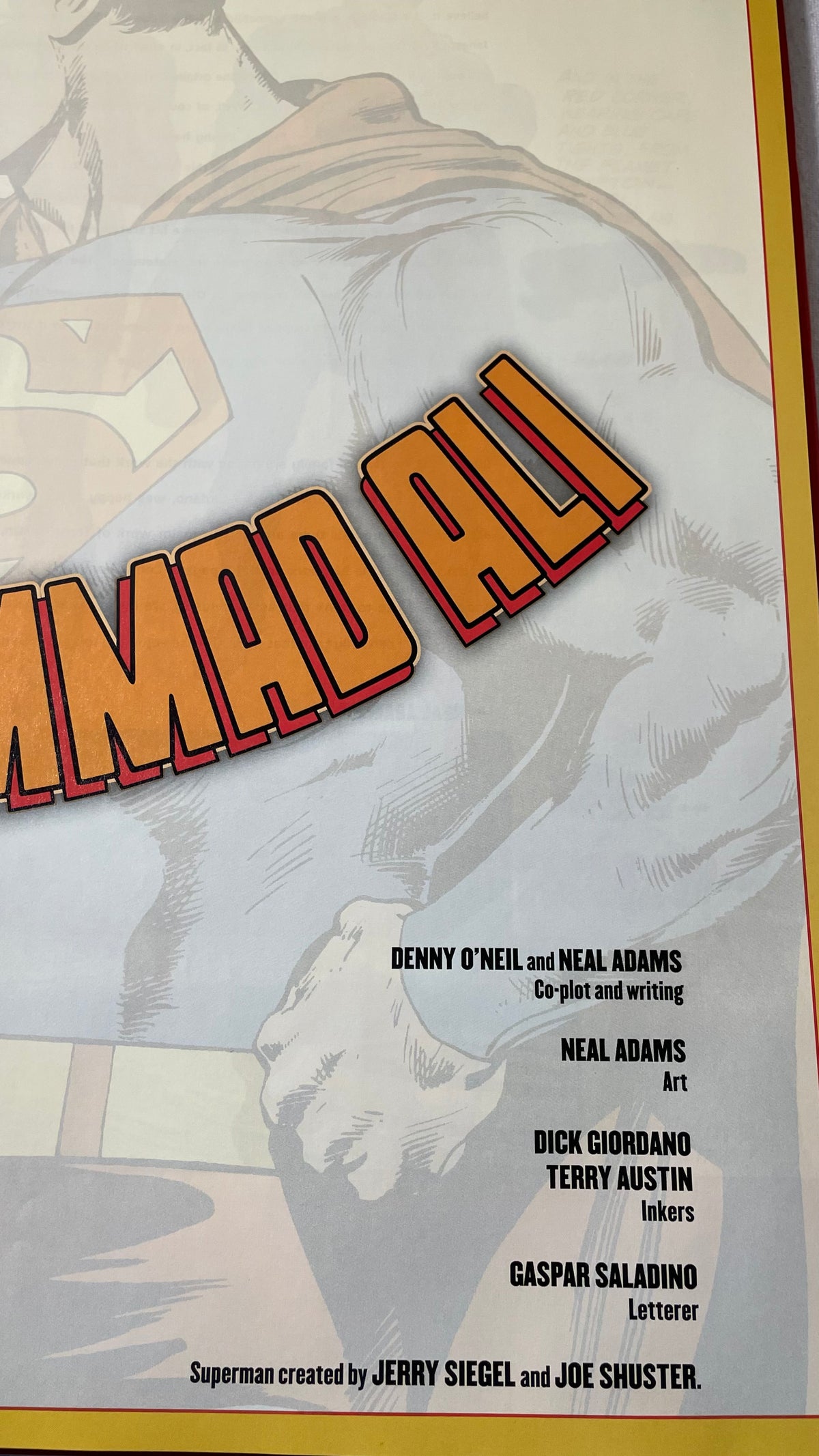 Creator credits in Superman vs. Muhammad Ali, with pale Superman artwork, cropped orange title lettering and a yellow border.
