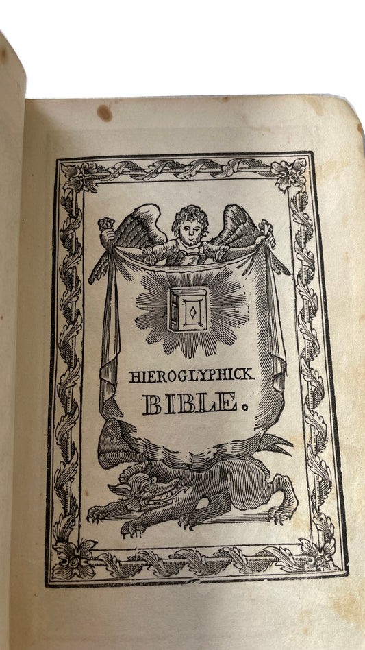 Decorative Hieroglyphick Bible title illustration with an angel, banner and dragon, from the 1841 edition.