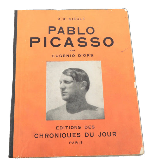 Orange front cover of Pablo Picasso by Eugenio d'Ors, with black lettering, a monochrome portrait, a dark spine strip and chipped edges.