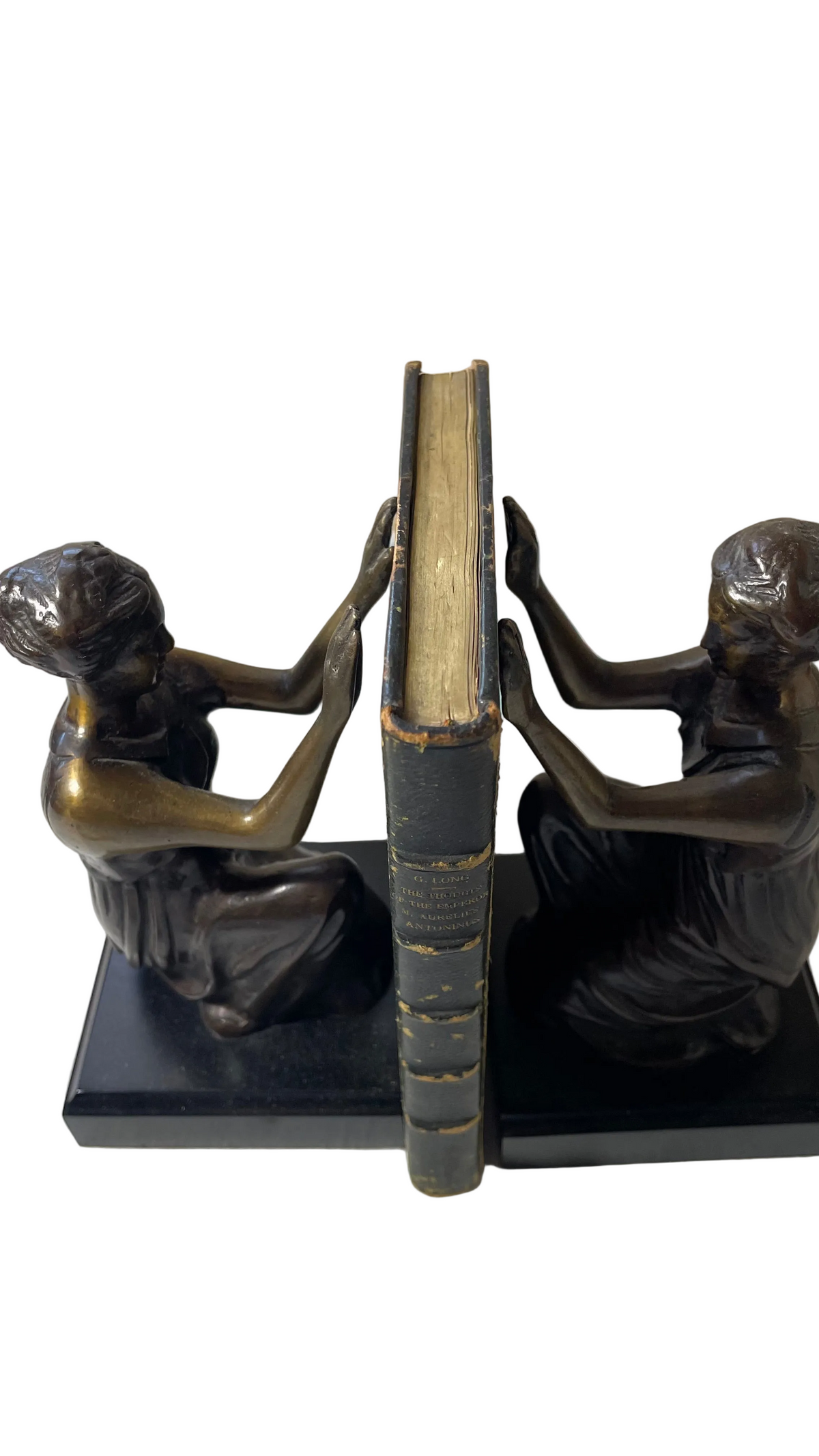 Top page edges and gilt-lettered green leather spine of Thoughts of the Emperor Marcus Aurelius Antoninus, showing worn headcap and surface losses, between bookends.