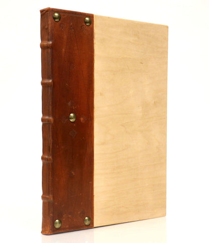 Closed Biblia Latina with the Glossa Ordinaria (c. 1480), showing a pale cover panel, brown spine and five round studs.