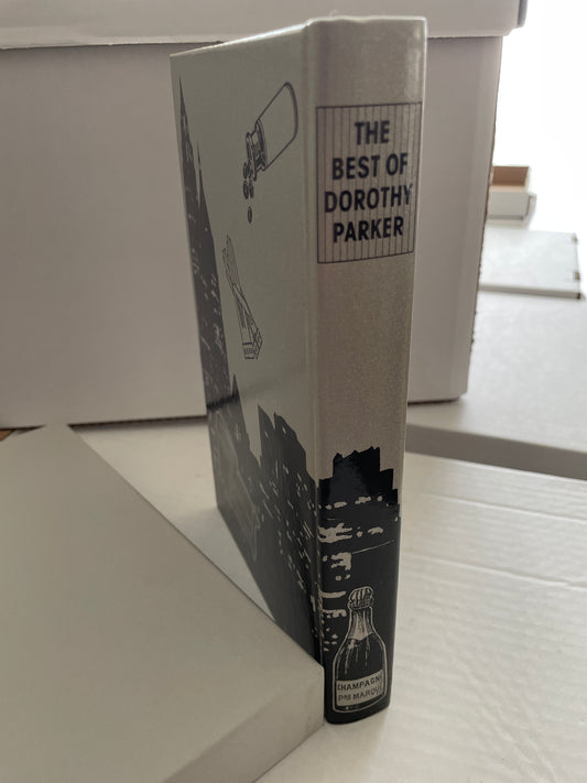Angled view of the spine and illustrated cover of The Best of Dorothy Parker beside its light-colored slipcase.