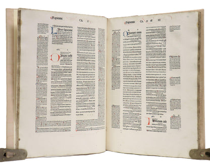 Sapientie spread in Biblia Latina with the Glossa Ordinaria, showing a blue L and red D on the left amid columns of black text.
