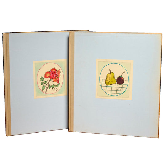 Clos Joli: two pale blue portfolios with mounted color pictures of flowers and fruit, standing side by side