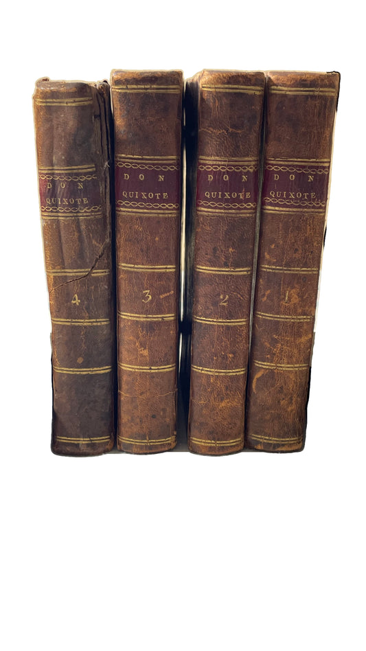 Four brown leather spines of Don Quixote, numbered 4, 3, 2 and 1, on a white background.