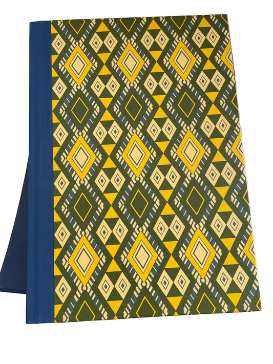 Front cover of Short Stories, with a blue cloth spine and yellow, cream and green geometric pattern; the blue slipcase lies underneath.