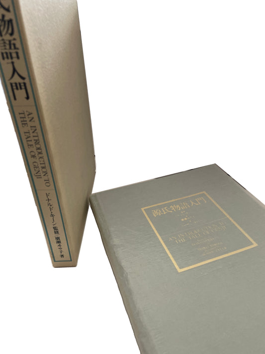 Cream titled case standing beside the gray-green cloth volume of An Introduction to the Tale of Genji, with its gold Japanese and English cover label.