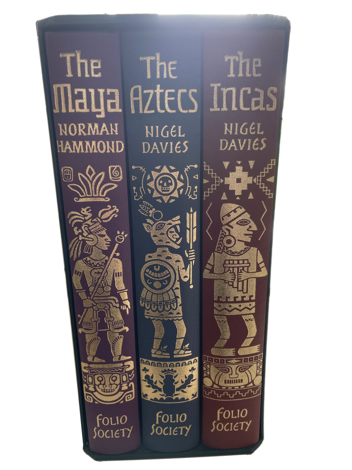 Spines of The Maya, The Aztecs and The Incas in their slipcase, with gold titles and illustrated figures on purple, blue and reddish-brown cloth.