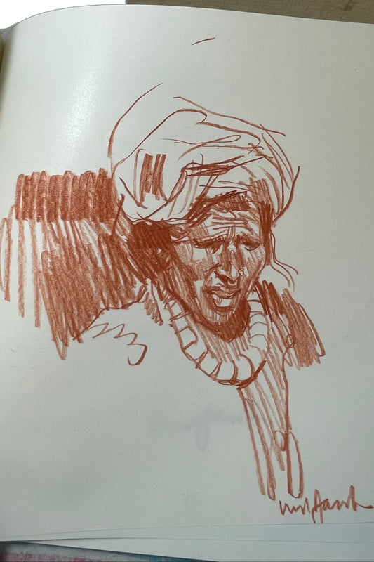 Original reddish-brown portrait drawing signed by Ned Jacob in Sacred Paint, with the surrounding paper and underlying leaves visible.