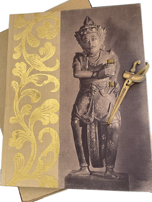 Decorated cover of Swords and Daggers of Indonesia over its cardboard slipcase, with the dagger-shaped ornament and ribbon resting diagonally across the illustrated figure.