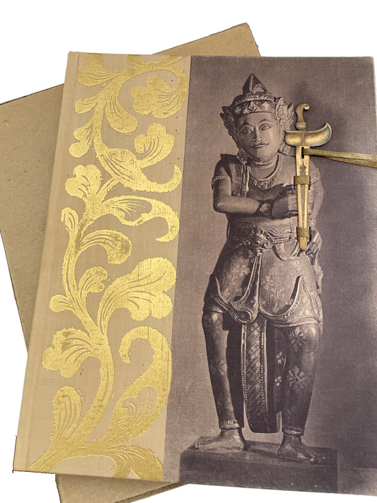 Cover of Swords and Daggers of Indonesia, with gold foliate decoration, a standing figure, a small dagger-shaped ornament secured by ribbons, and its cardboard slipcase beneath.